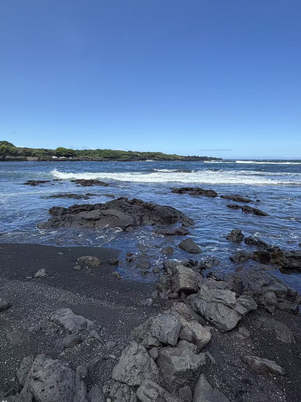Black lava rocks and ocean at a black sand beach